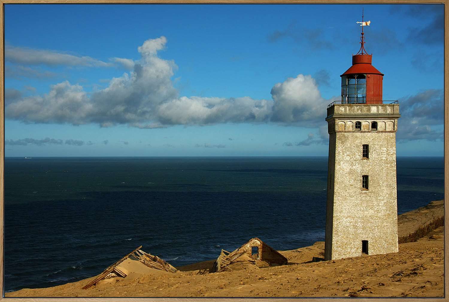 Akustikbild im Eichenrahmen, frontal, Motiv: Leuchtturm mit roter Laterne auf einer Sanddüne über dem Meer.