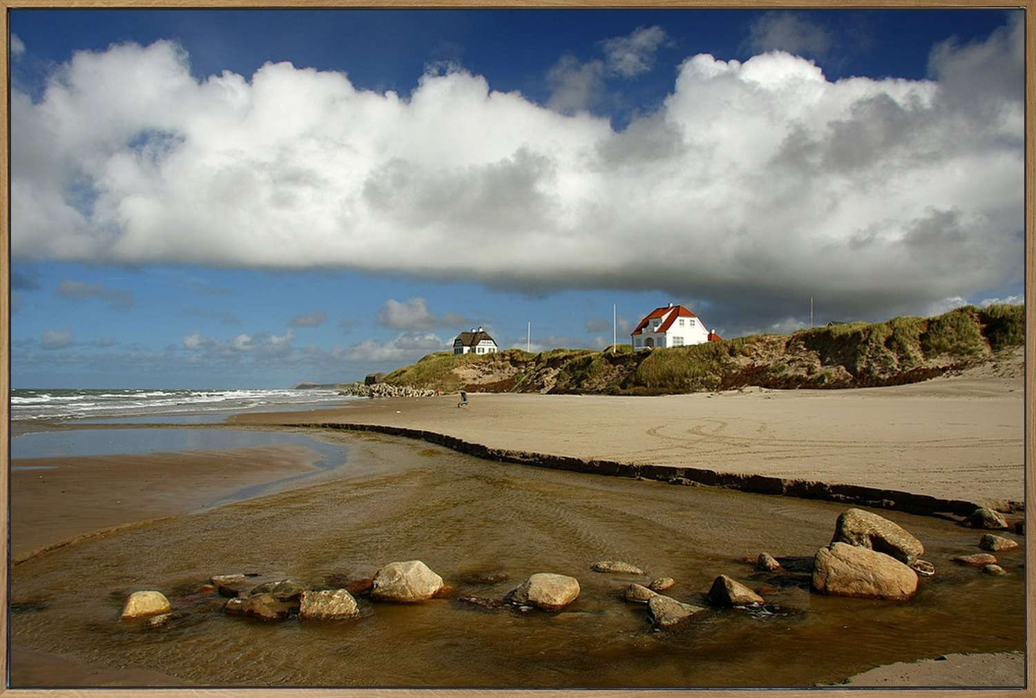 Akustikbild im Eichenrahmen, frontal, Motiv: Sandstrand mit Steinen, Priel und weißen Häusern auf der Düne bei Løkken.